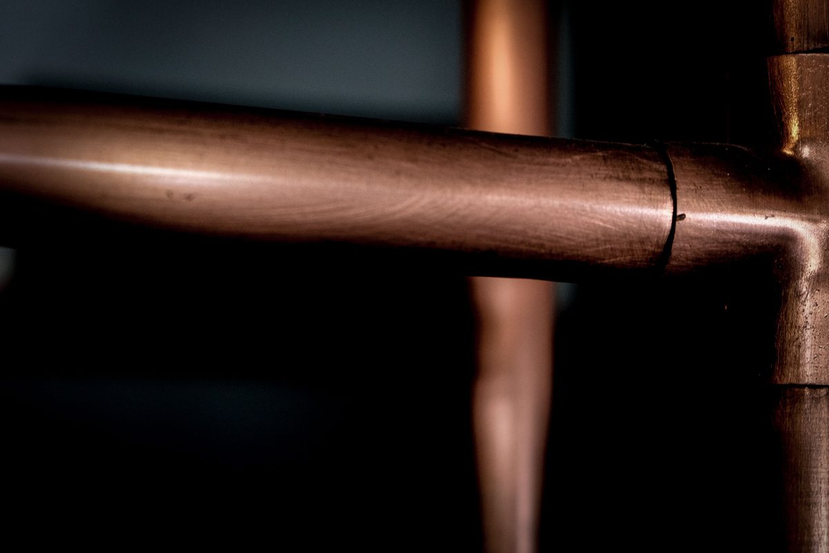 Close-up of a copper pipe joined to a copper tee fitting