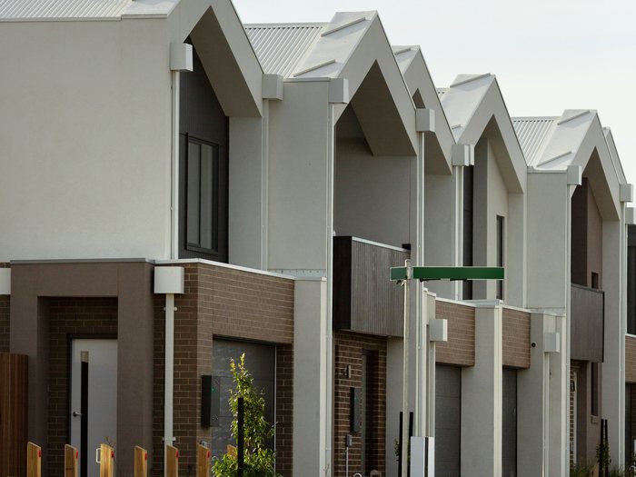 Row of modern two-storey rendered and brick townhouses with garages